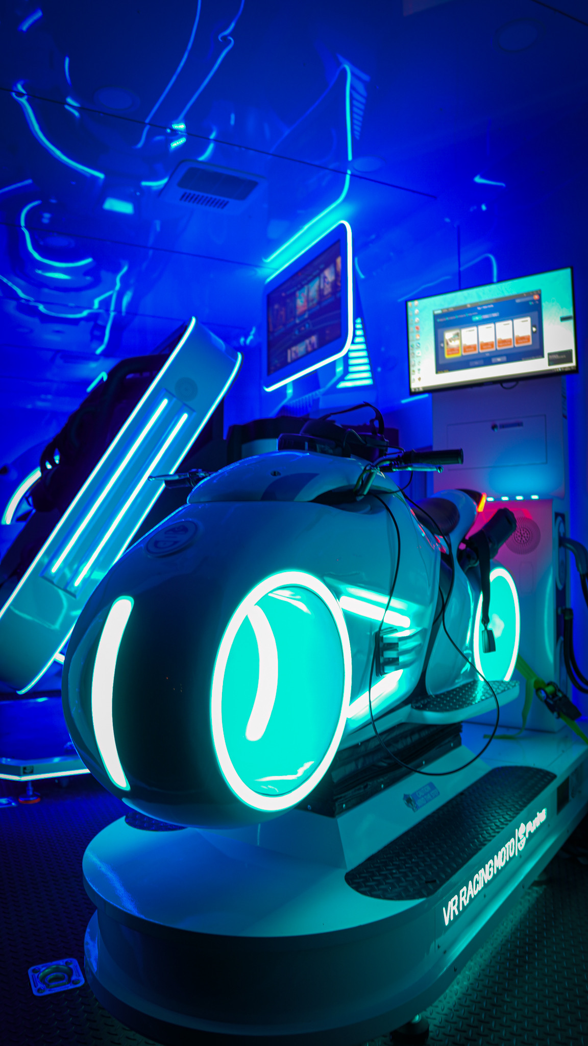 VR Racing Moto pod with glowing teal neon wheels