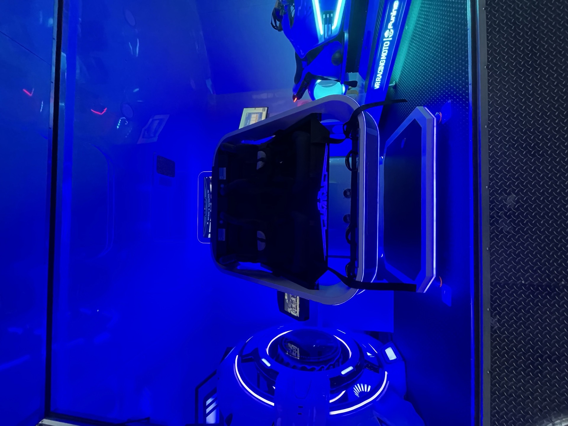 Single VR experience seat with blue neon lighting inside the trailer