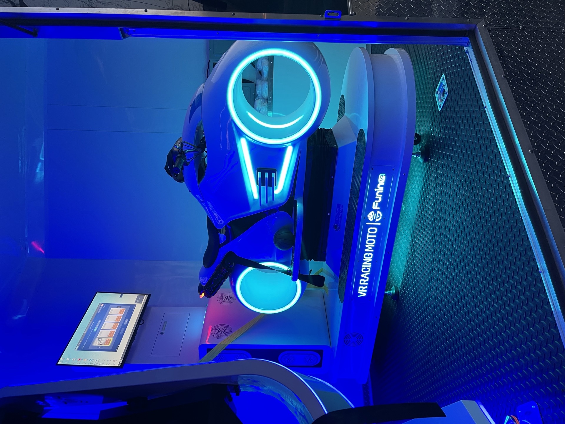 VR Racing Moto motorbike pod with blue neon wheels inside the VR trailer